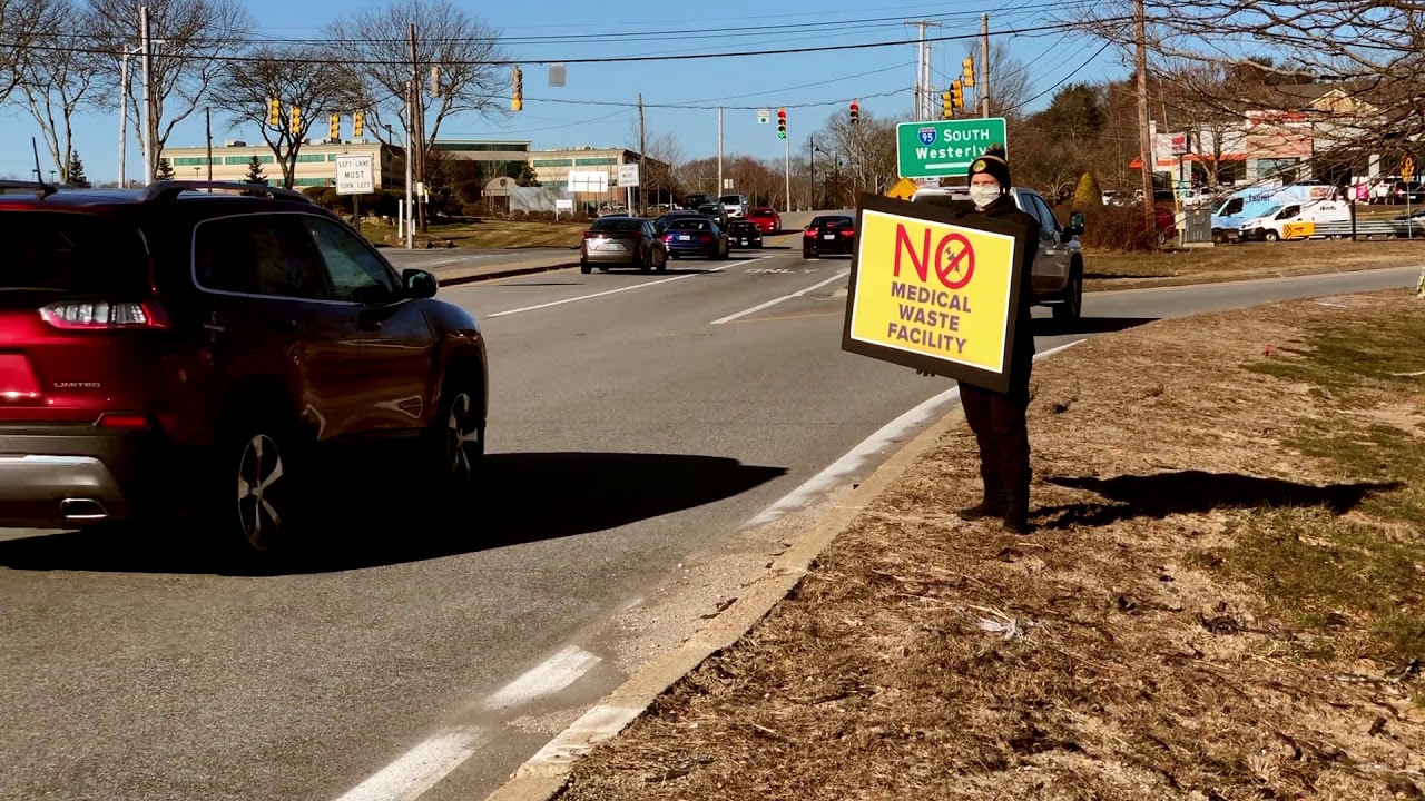 Local Groups Hold Signs Near a Road to Rally Against Proposed Medical Waste Facility in West Warwick