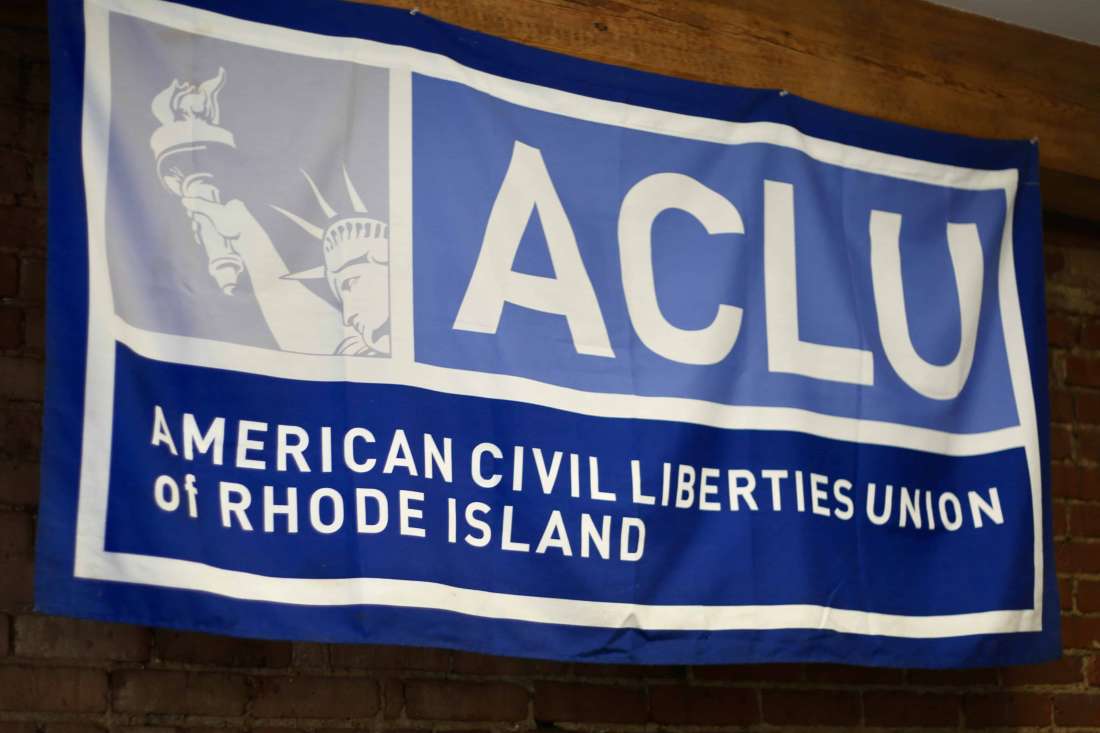 RI ACLU Banner, blue and white, on a brick wall
